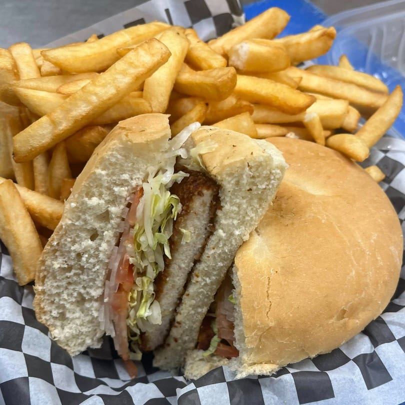 A Romeo's Italian Submarines sandwich, cut in half, with fries in a checkered basket.